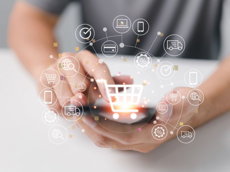 Online shopping and e-commerce technology concept, shopper using smartphone to input order with credit card delivery truck.